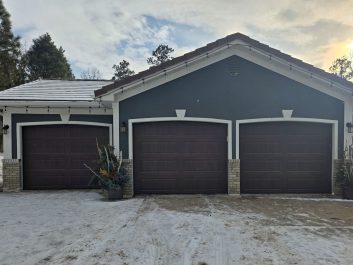 Blue house with new residential garage doors after photo