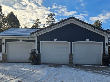 Blue house with white residential garage doors before photo