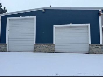 Blue garage with white residential garage doors before photo