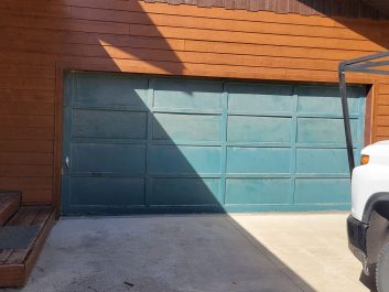 green garage door showing wear signs